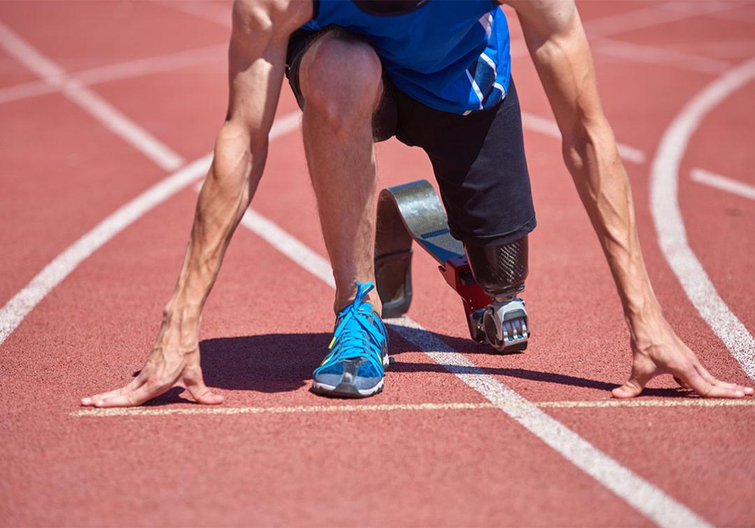 A paralympic athlete is poised ready to run on an athletic track