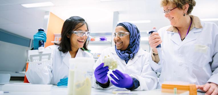 Three woman sharing a moment in a laboratory