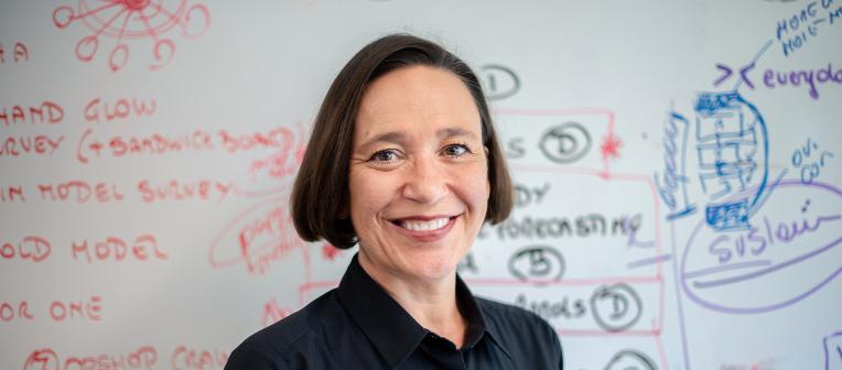Professor Sara Dolnicar standing in front of a used whiteboard