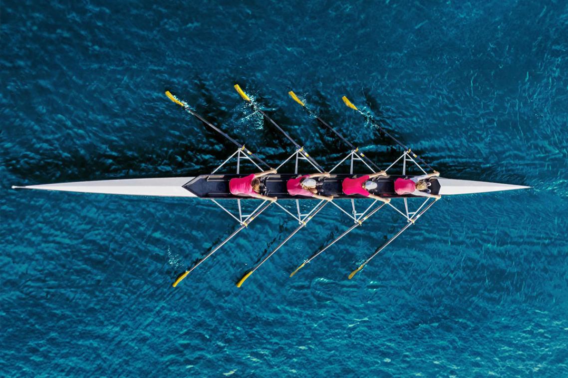 Rowers in a long rowing boat.