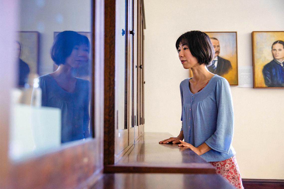 Former student looking into a display cabinet