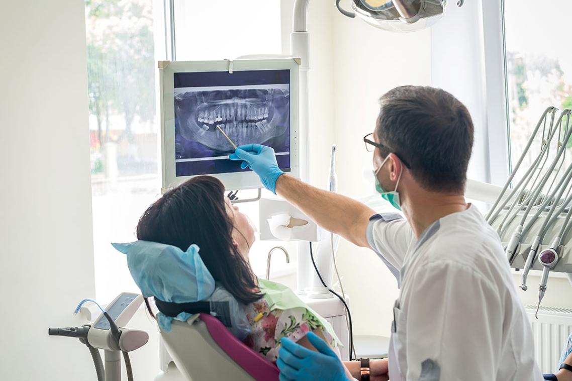 Dentist shows patient an x-ray of teeth