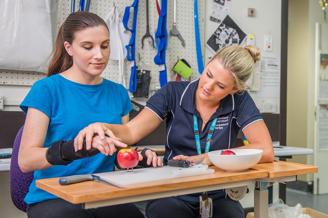 Occupational therapist helps women with hand movement.