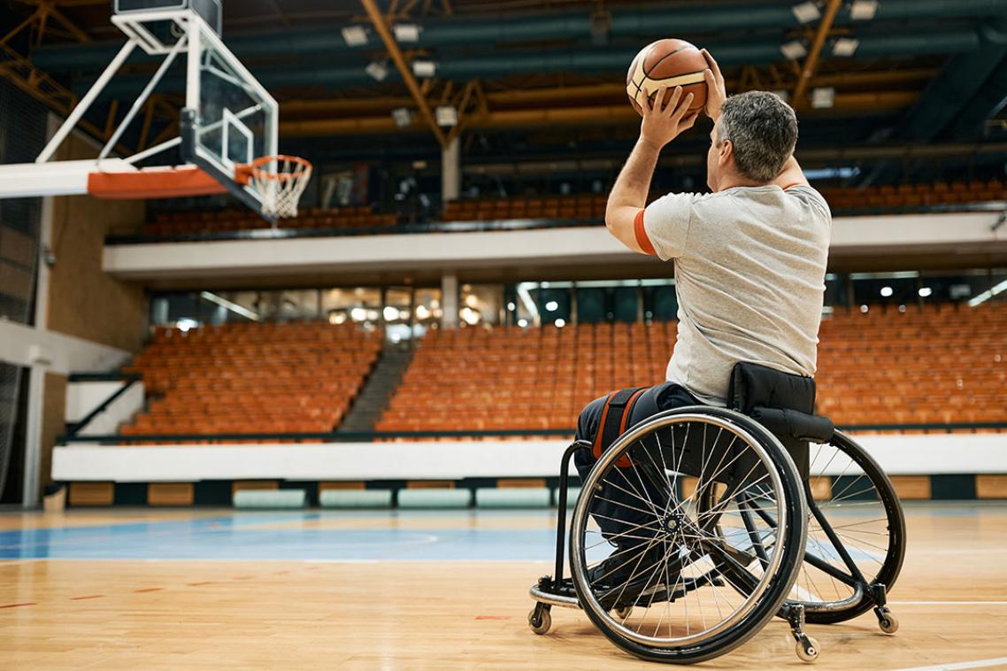 Man in wheelchair throws a basketball