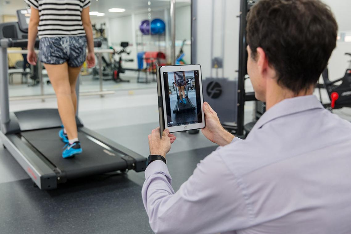 Man with ipad records a persons walking pattern