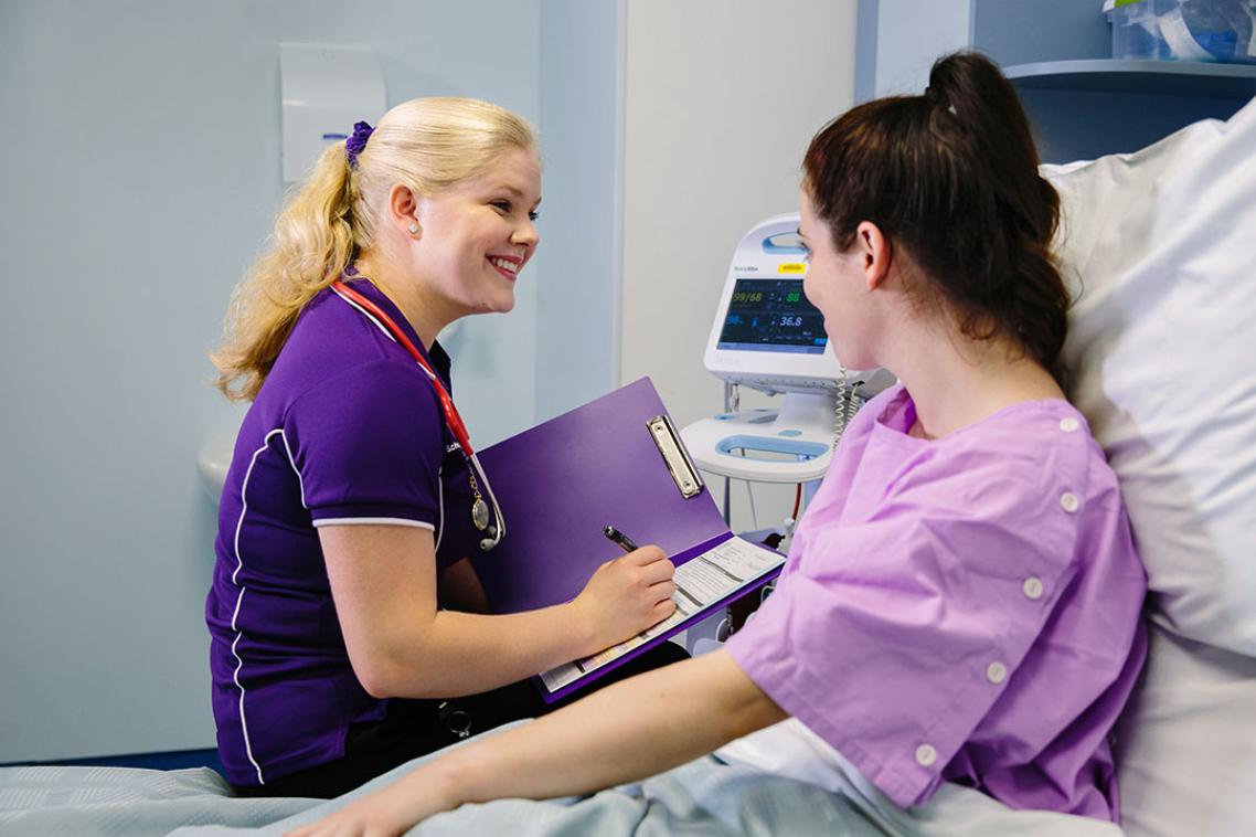 Student nurse talking to a volunteer patient