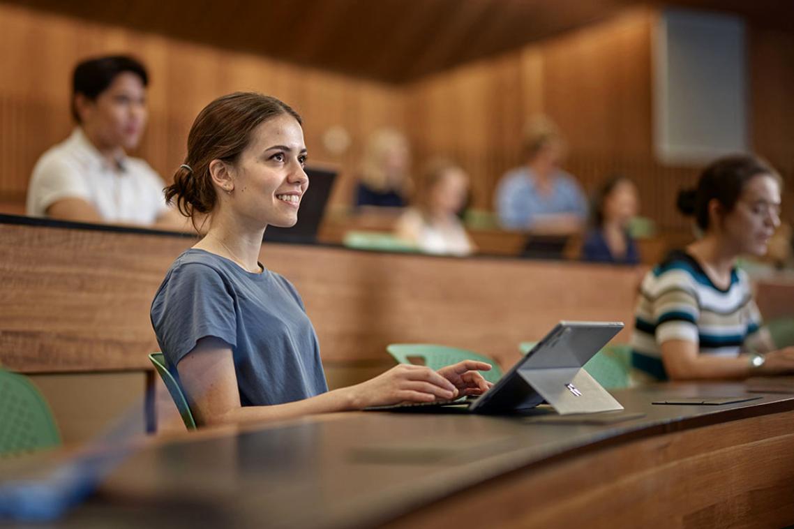 Student with laptop in lecture theatre