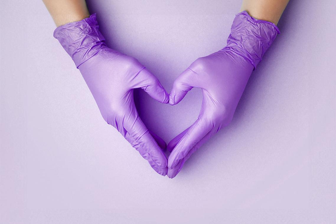 Purple gloved hands forming a heart shape