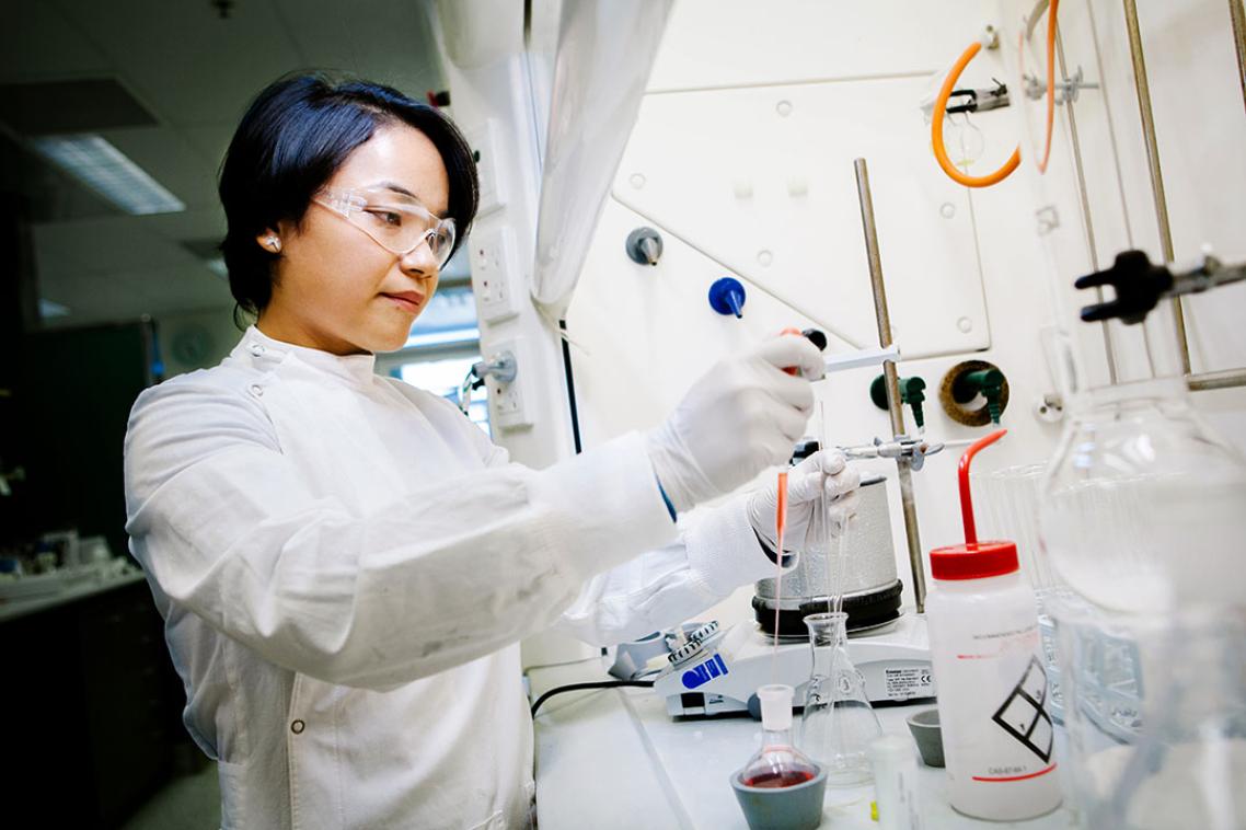 A researcher adjusting lab equipment