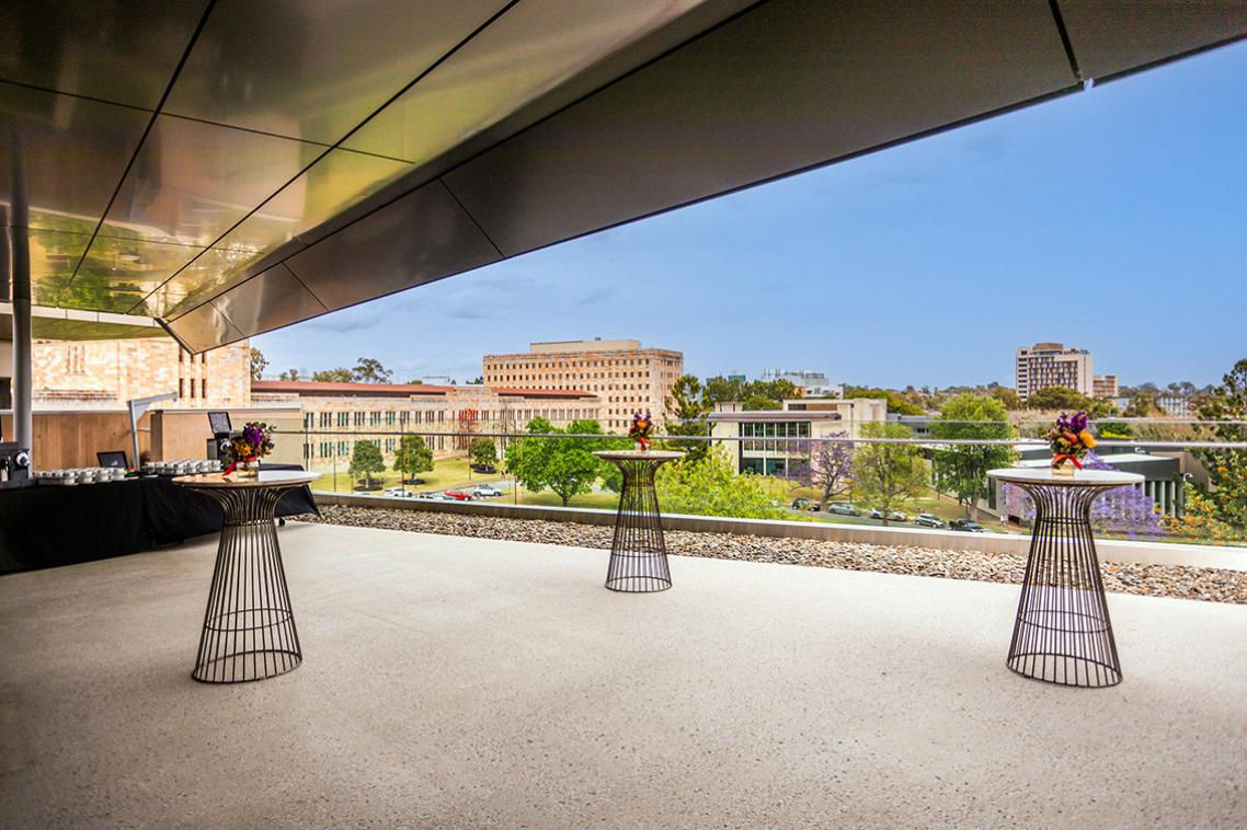 The outlook from the terrace. A bright blue sky and sandstone building is visible