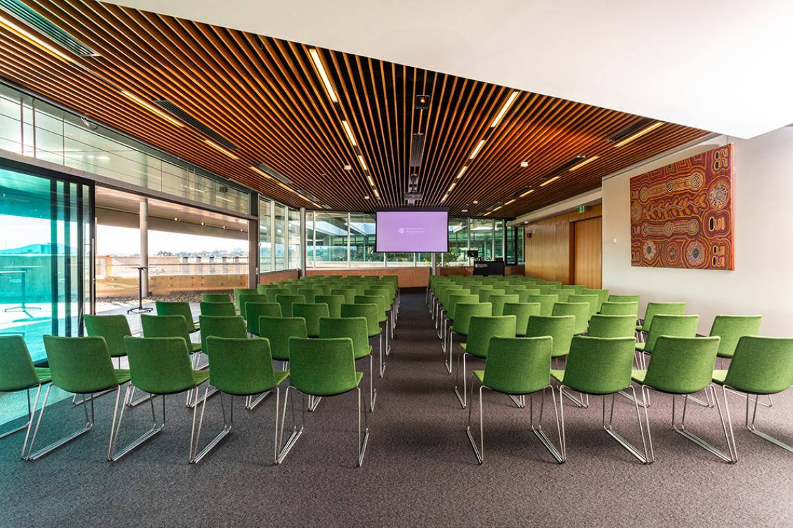 An interior view of the Terrace Room, showing auditorium-style seating, with a screen at the front of the room