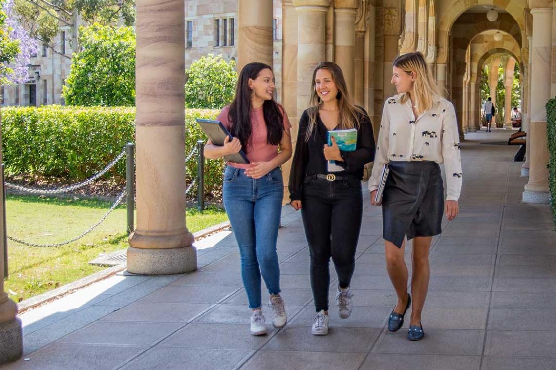 three students walking under arches at UQ Great Court
