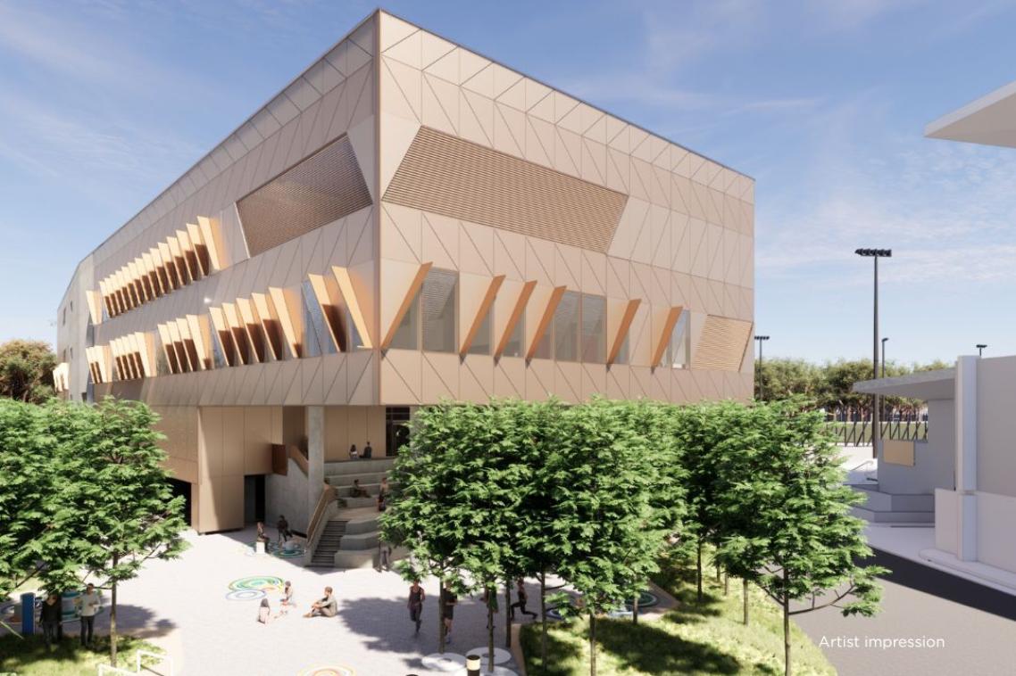 Exterior view of a modern, angular, sandstone faced building with sunny forecourt and shaded under-croft stairway to entry.