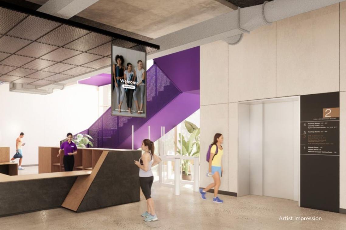 A spacious, modern reception area with purple staircase in background and sleek reception desk in foreground.
