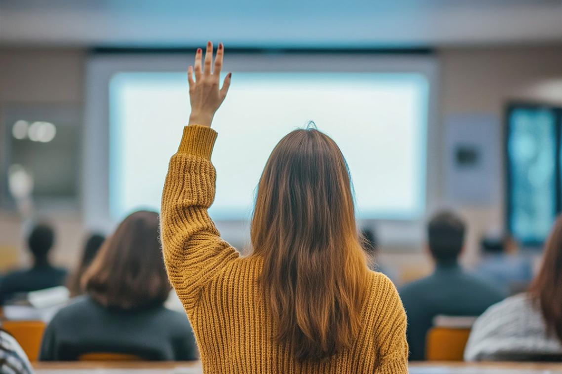 Woman with hand raised in a class or workshop.